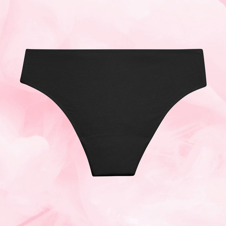 ComfortFit Essentials Brazilian menstruse, svart, flattliggende på rosa bakgrunn.