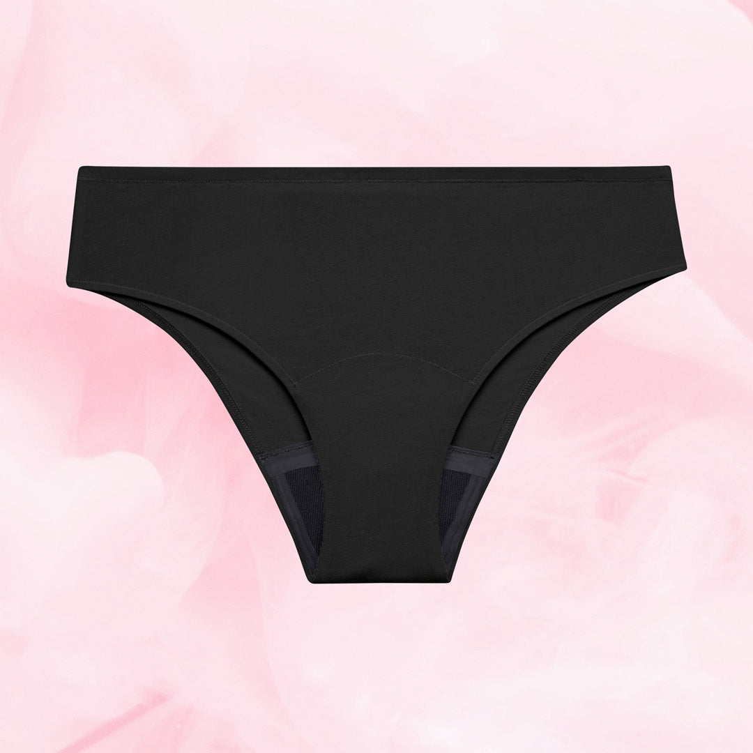 ComfortFit Essentials Brazilian menstruse, sort, flatt mot rosa bakgrunn.